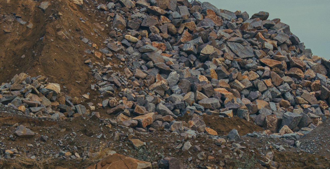 Grande monte de pedra empilhado ao ar livre sobre um talude de terra